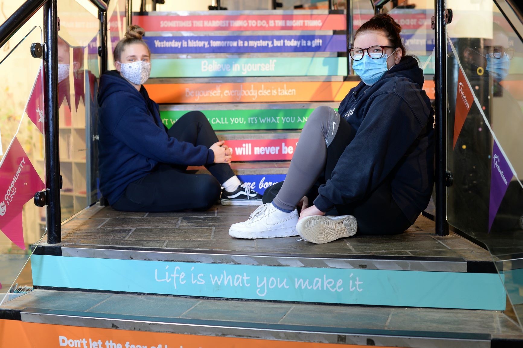 Two volunteers sitting on the motivation steps within the hub